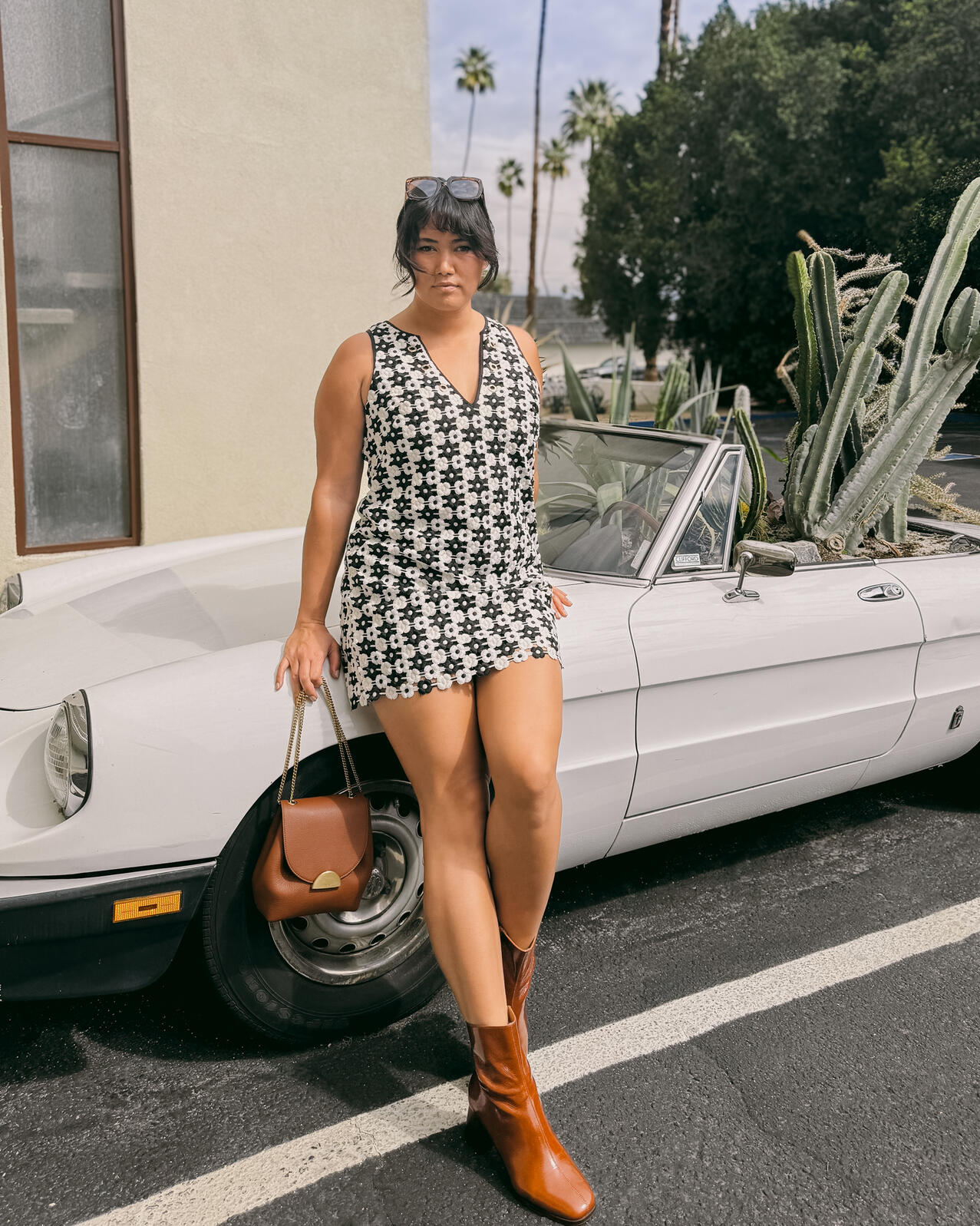 Sarah Alona stands by a vintage car art installation that is filled with cacti at Life House Palm Springs hotel.