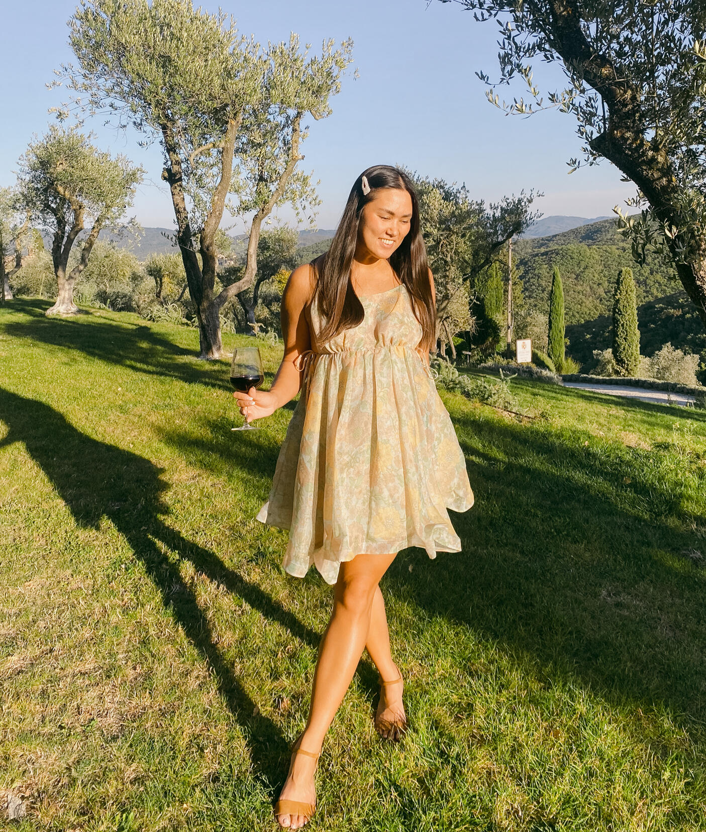 Sarah creating user generated content in the vineyard of Borgo Vescine in Tuscany, Italy, holding a glass of wine.